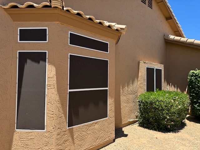Restored solar screens in white frames on a tan stucco Phoenix home