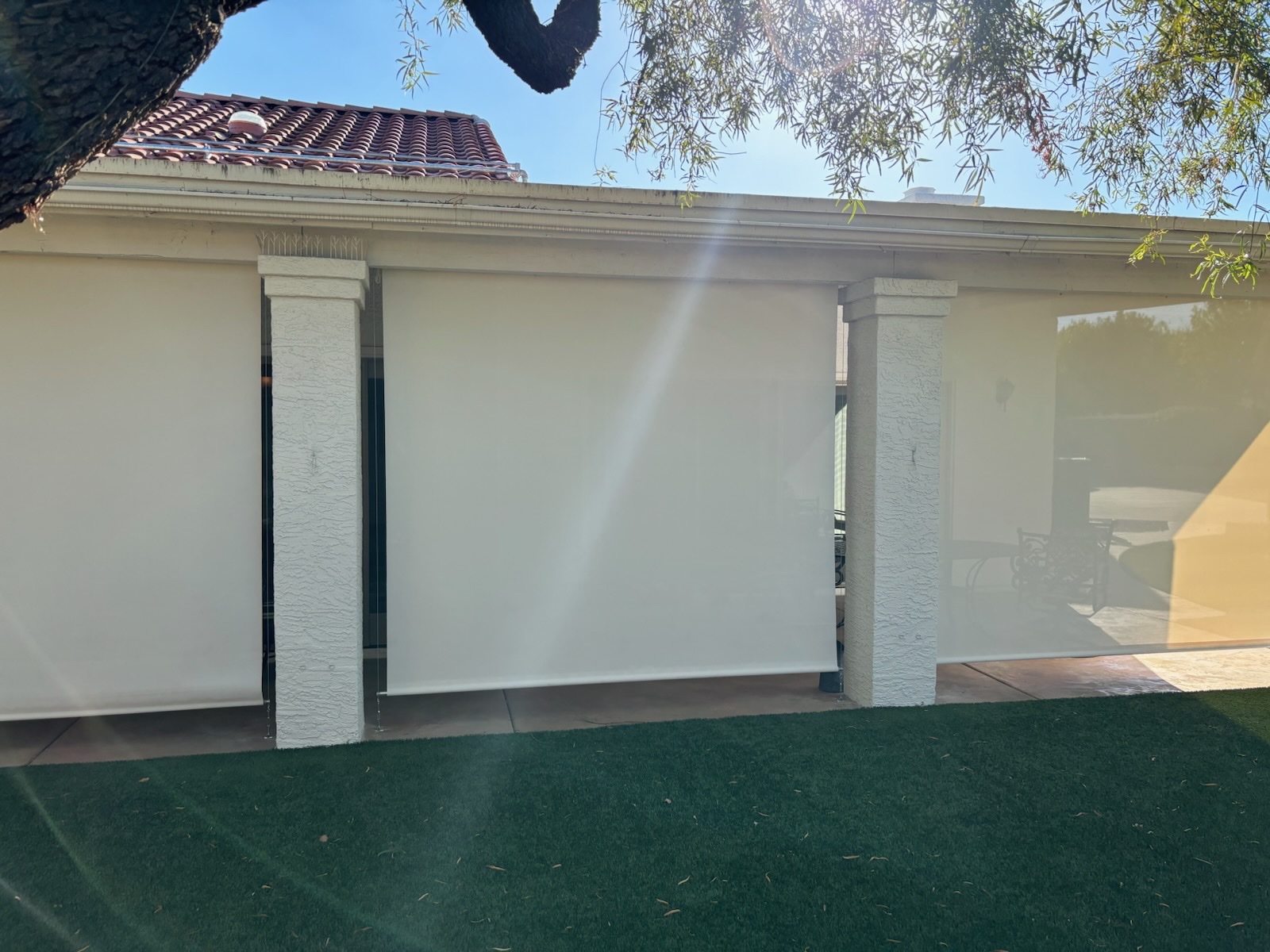 Cream roll-down patio shades between two pillars on a Scottsdale patio after ScreenRevive cleaning