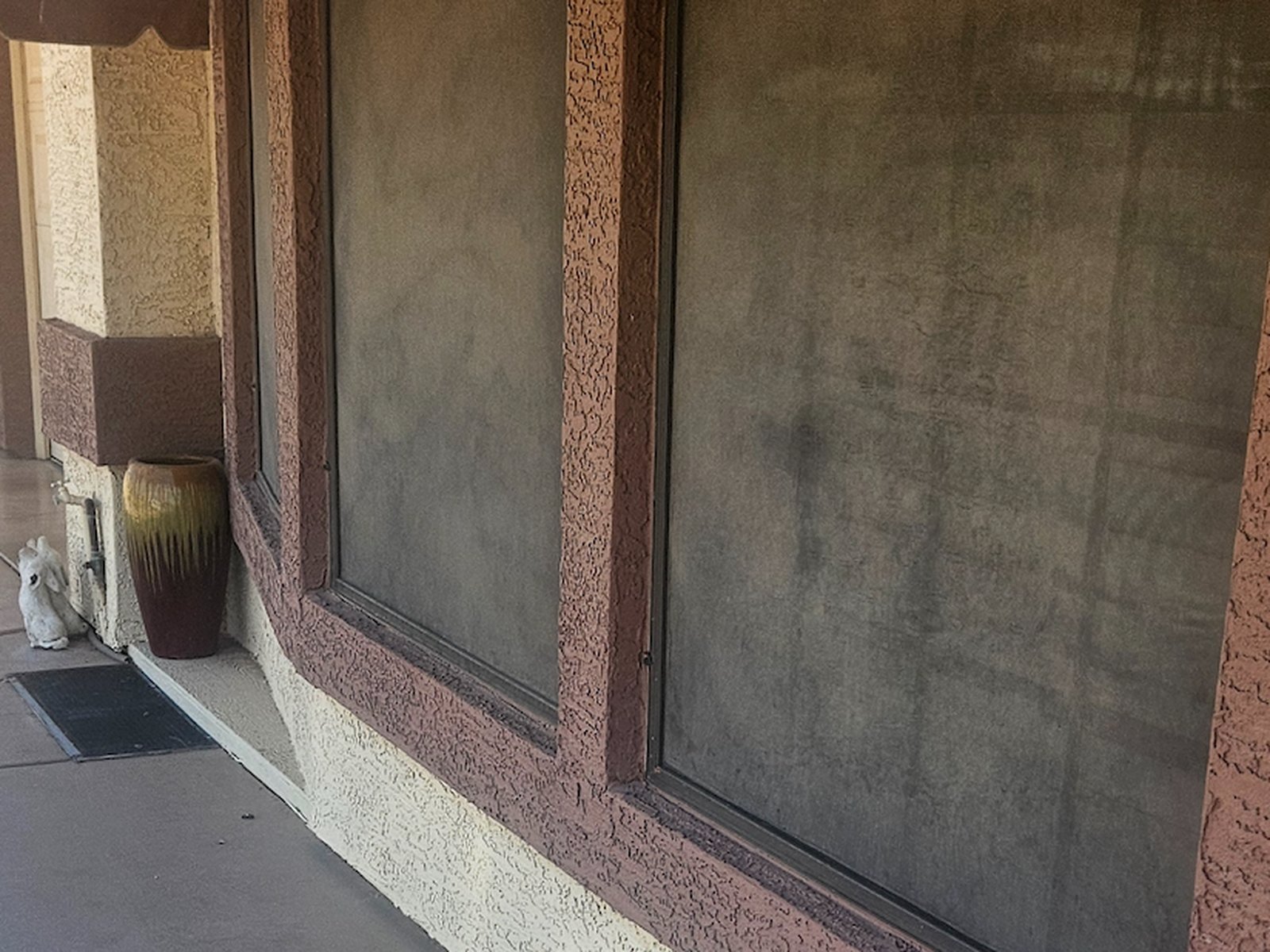 Close-up of dusty, hazy window sunscreens on a Sun Lakes commercial property